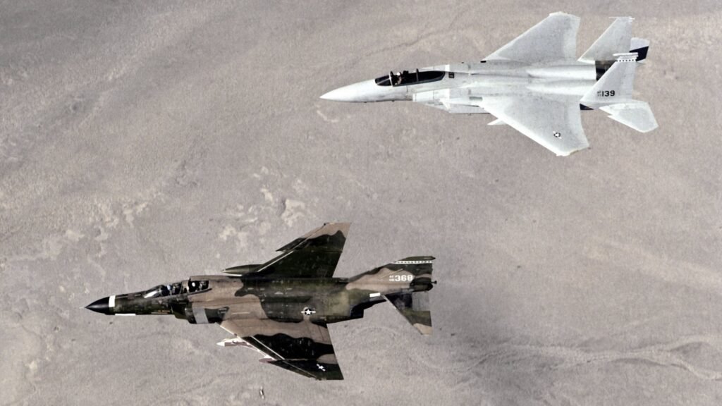U.S. Air Force F-4 Phantom and F-15 Eagle in formation flight over the desert, illustrating Cold War aviation technology across two generations of fighter aircraft.